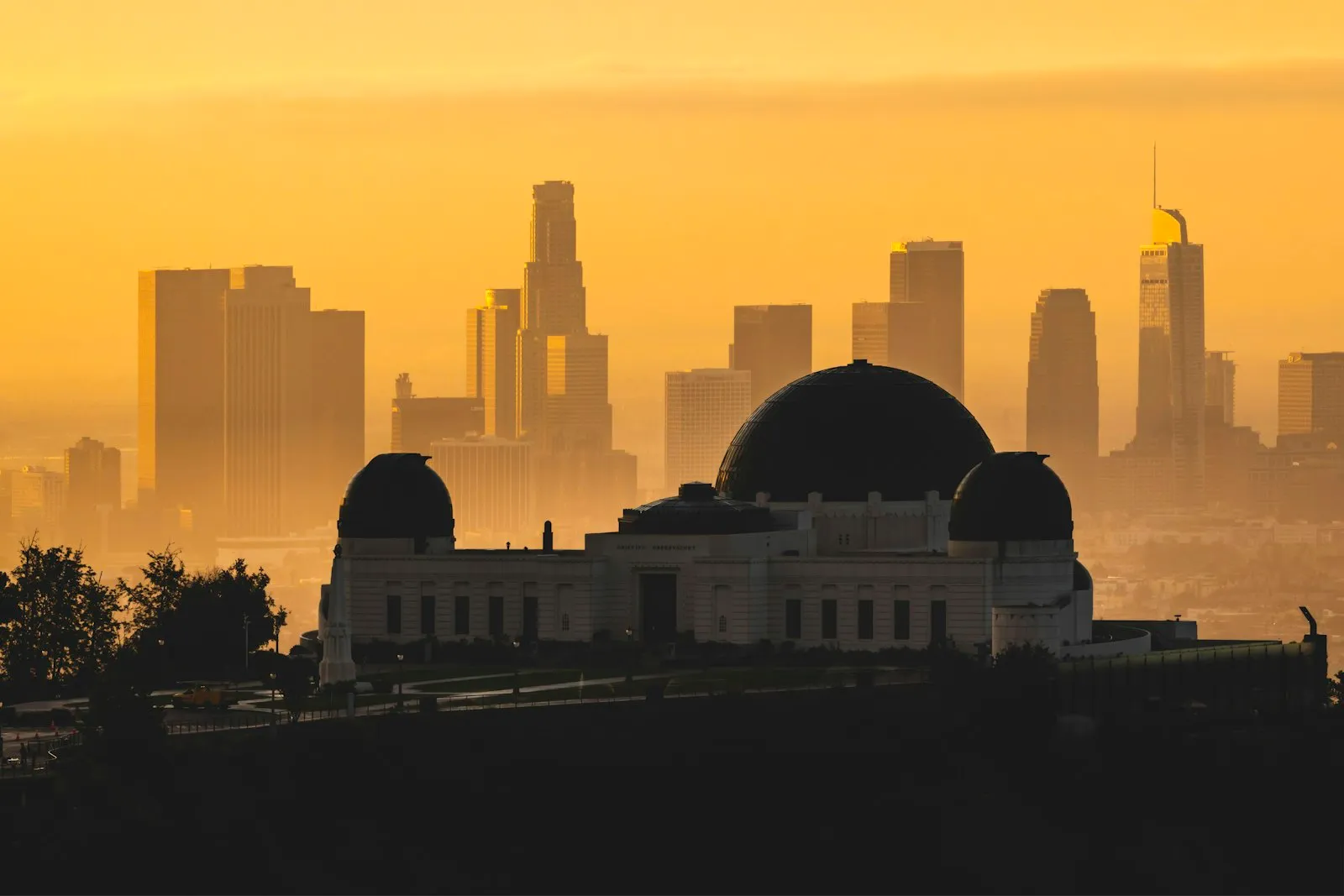 金色暮光中的 Griffith Observatory 与远处 Downtown LA 的天际线