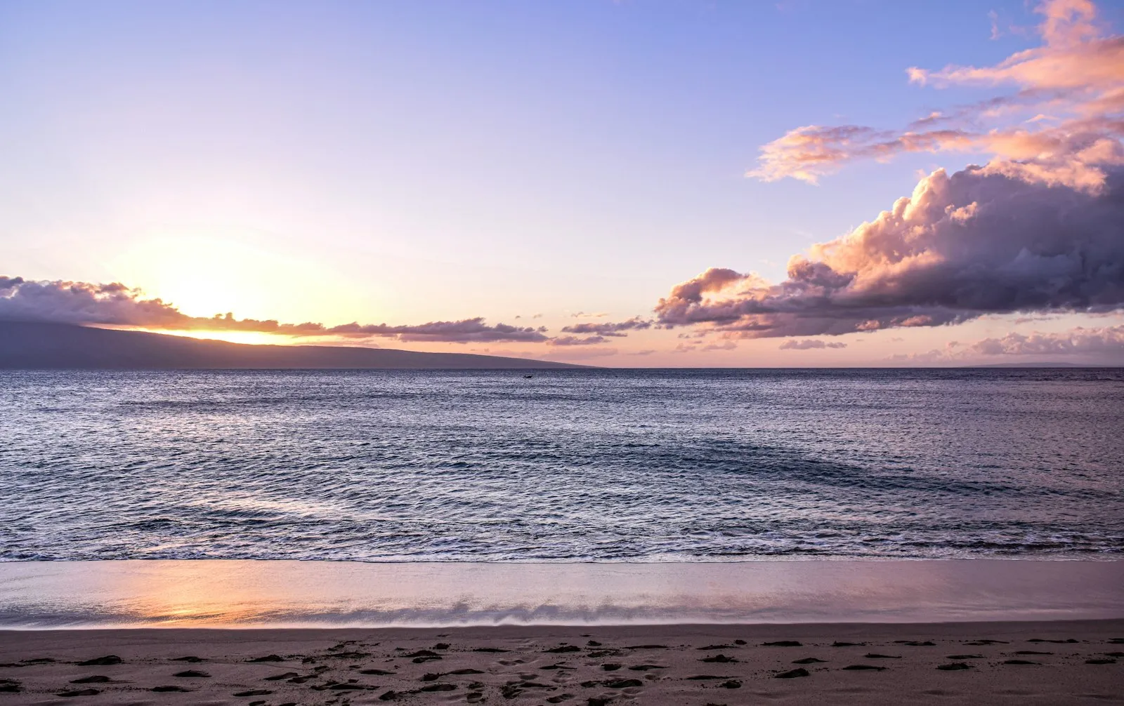 Kāʻanapali 沙滩的粉紫色日落，远处是 Lānaʻi 岛的剪影