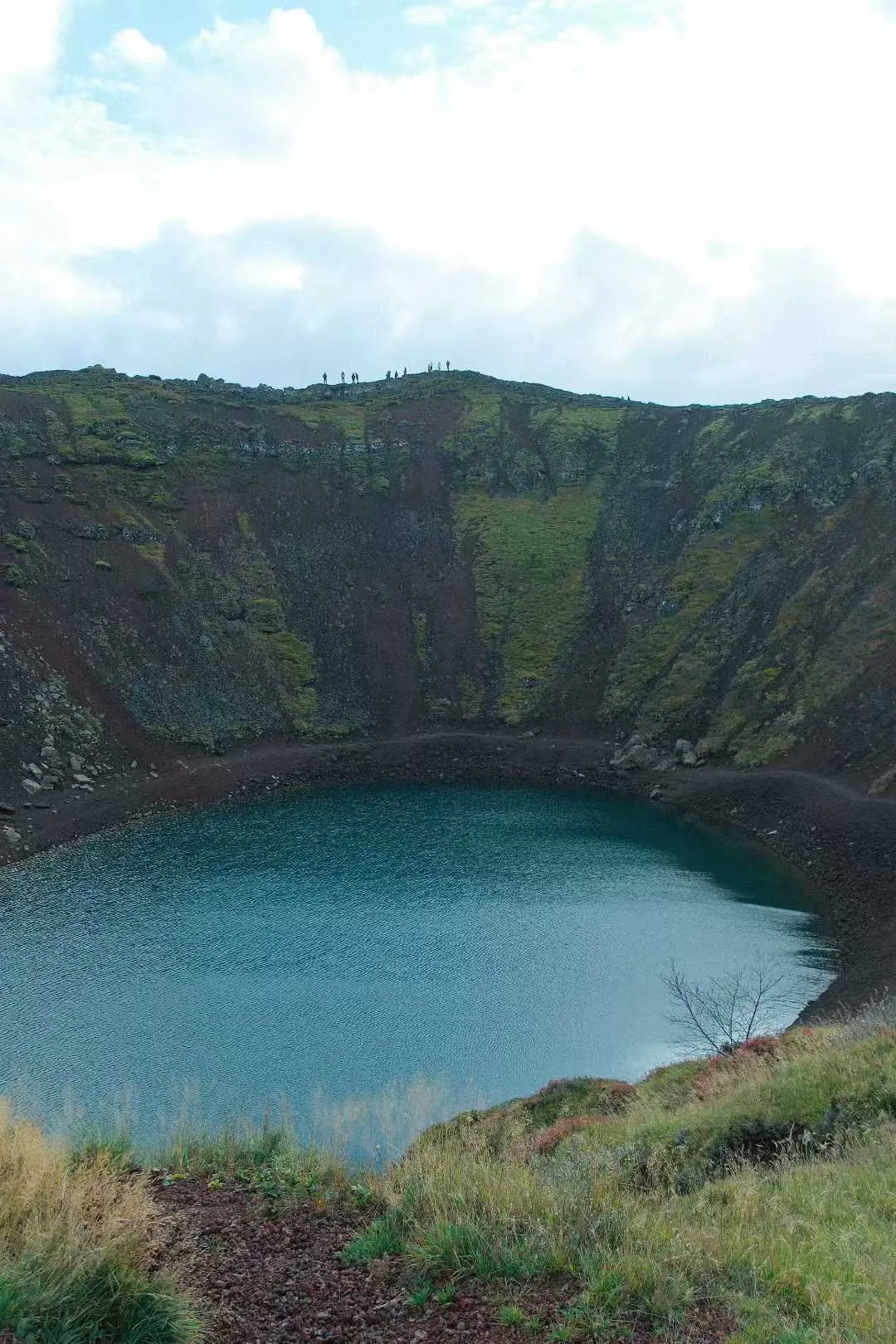 Kerid 火山口湖，湖水呈蓝绿色，四周是红褐色火山岩