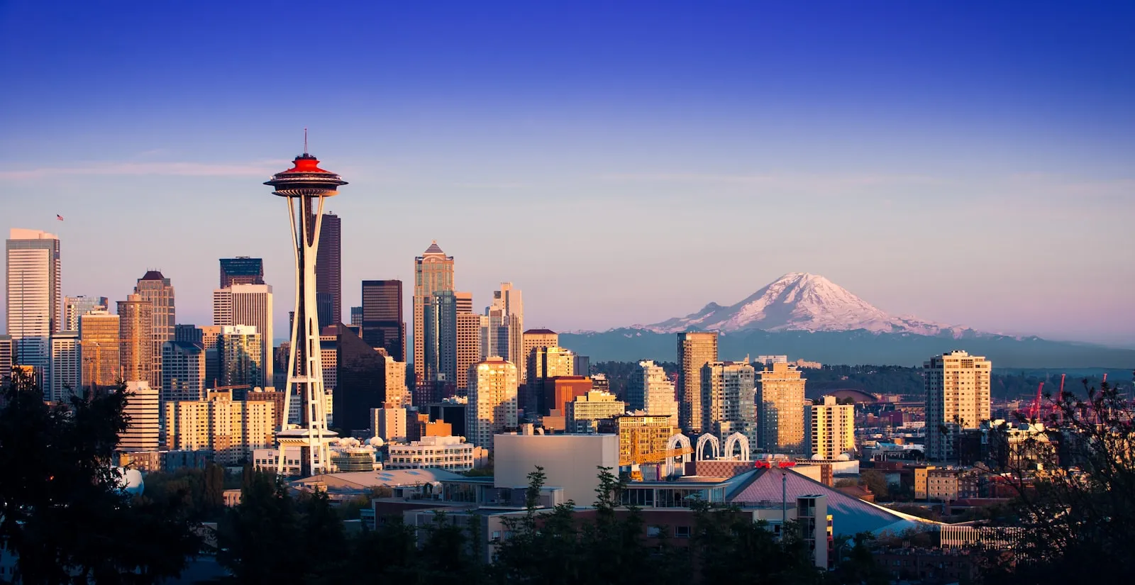 从 Kerry Park 眺望西雅图天际线，太空针居中，远处是覆雪的雷尼尔山