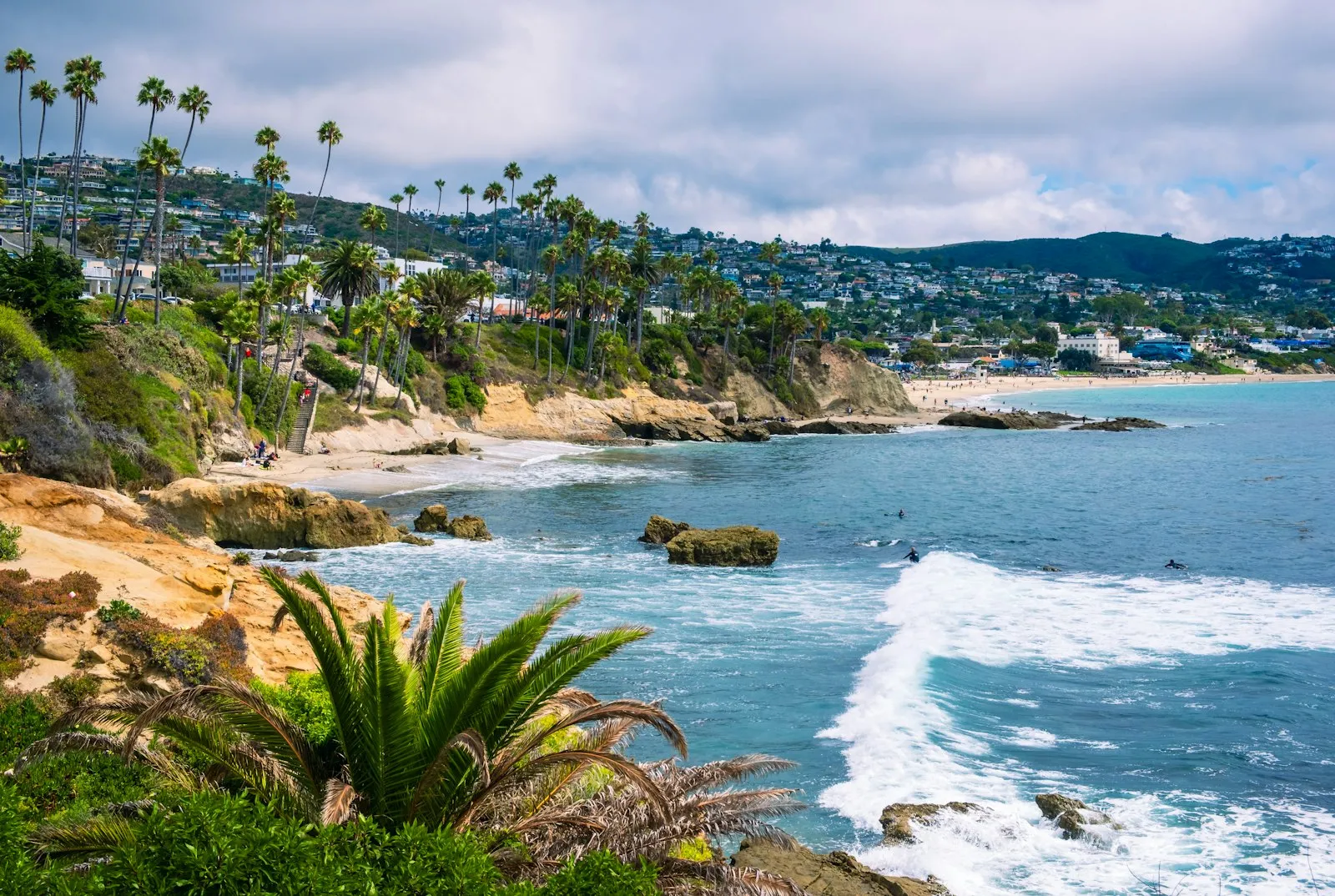 Laguna Beach 的 Heisler Park:棕榈树、礁石海湾、碧蓝海水和山坡上的小镇