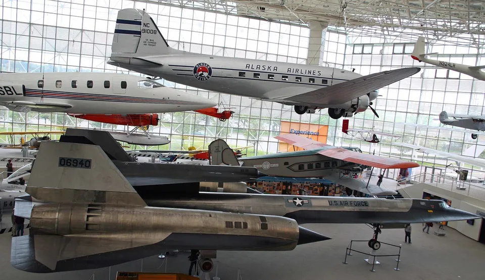 飞行博物馆大展厅内悬挂的多架飞机，包括一架 SR-71 黑鸟