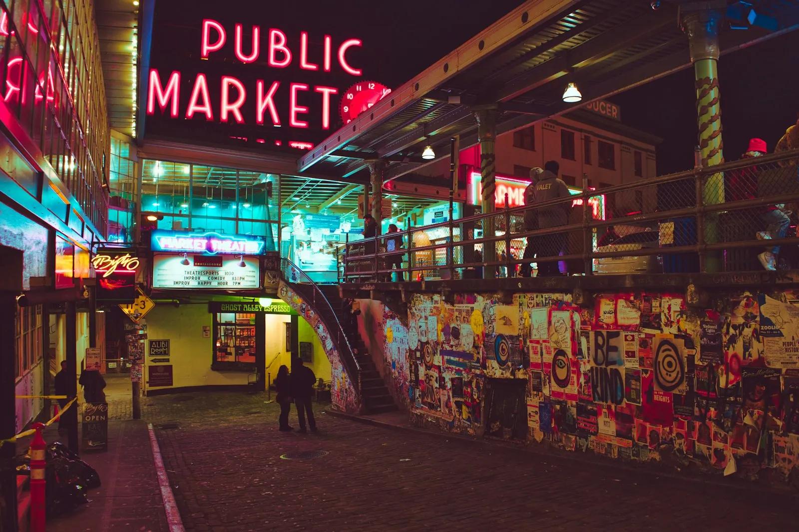 夜色中 Pike Place Market 的 Public Market 霓虹招牌、Market Theater 与贴满海报的坡道墙