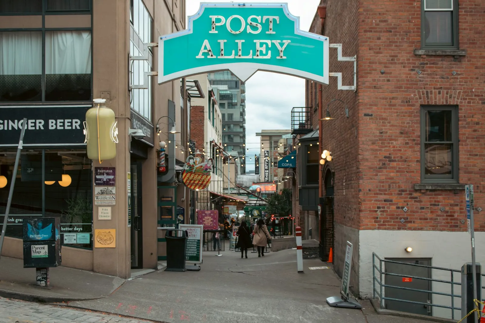 Post Alley 青绿色的招牌和红砖巷子，巷内挂着串灯