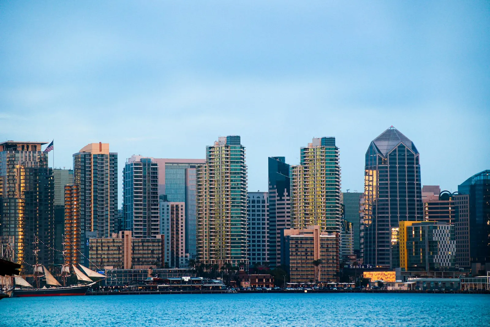 傍晚从海湾看 San Diego 市中心的天际线,前景是一艘帆船