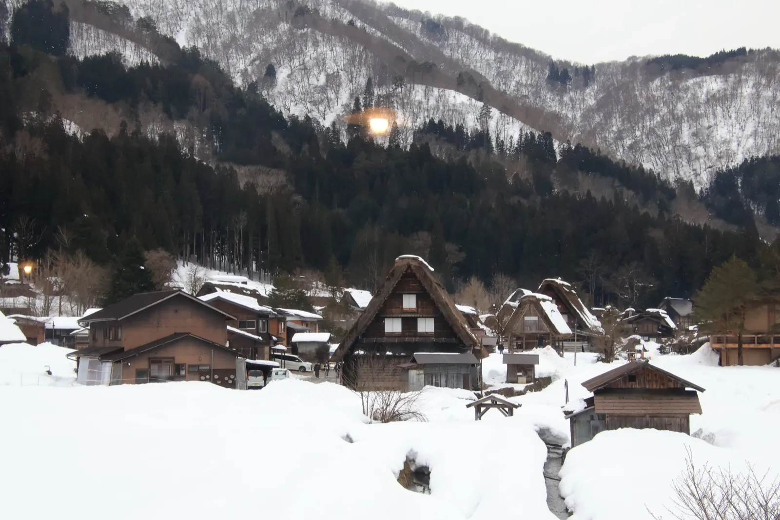 雪山脚下成片的合掌屋村落,屋顶与田野都被白雪覆盖