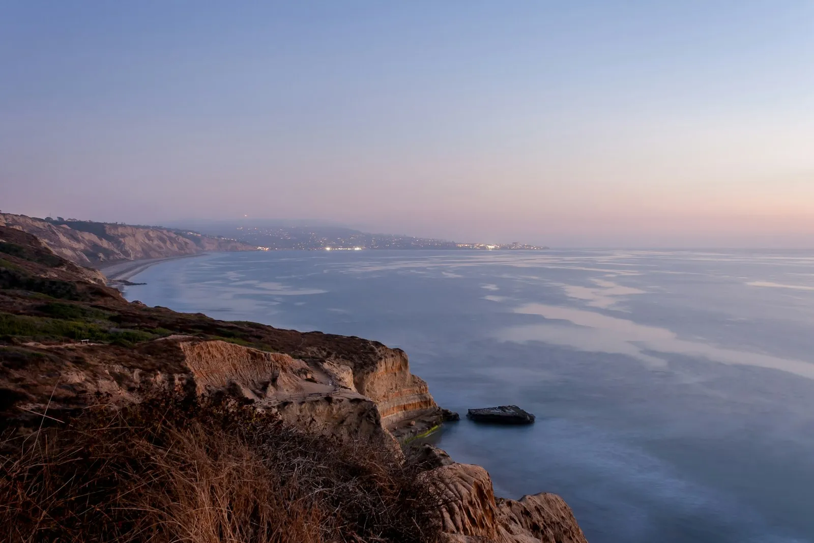 黄昏时从 Torrey Pines 崖顶俯瞰海岸线,远处是 La Jolla 的灯火
