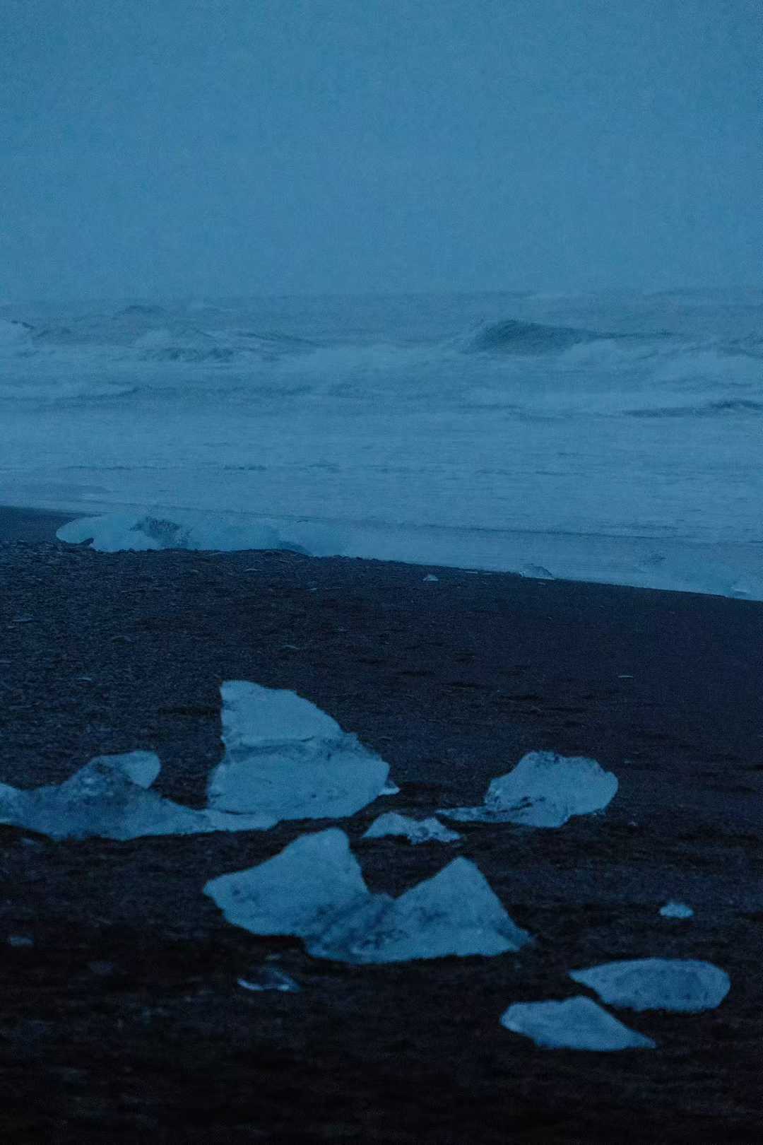 钻石沙滩夜景，黑色沙滩上散落着蓝白色冰块