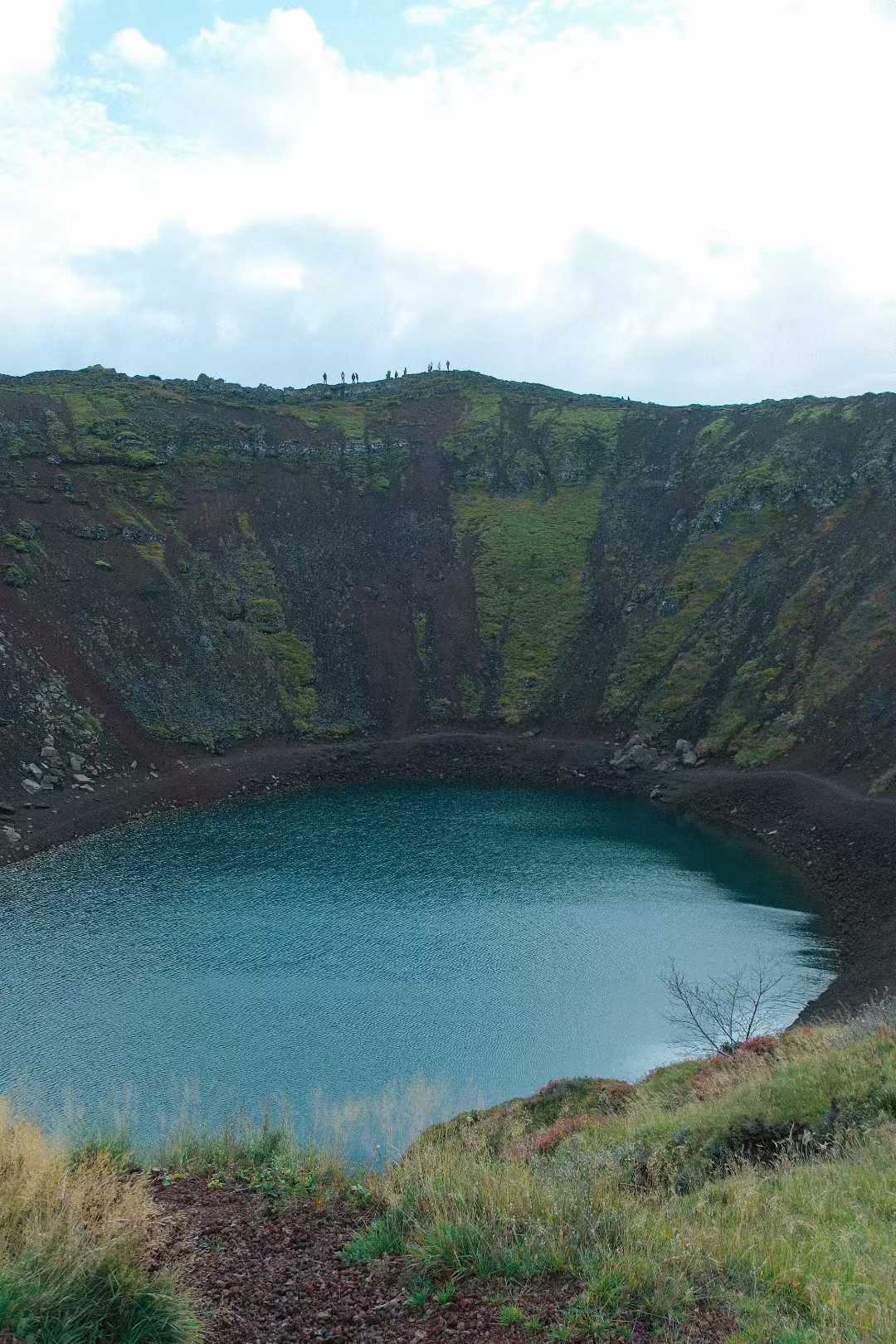 Kerid 火山口湖，湖水呈蓝绿色，四周是红褐色火山岩