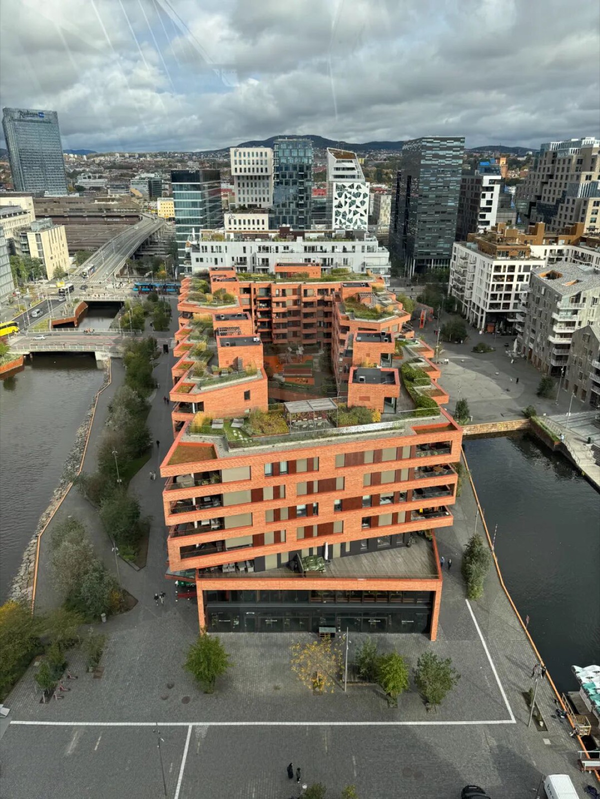 从蒙克美术馆天台俯瞰奥斯陆，近处是橙色建筑群与河流，远处是错落的城市天际线